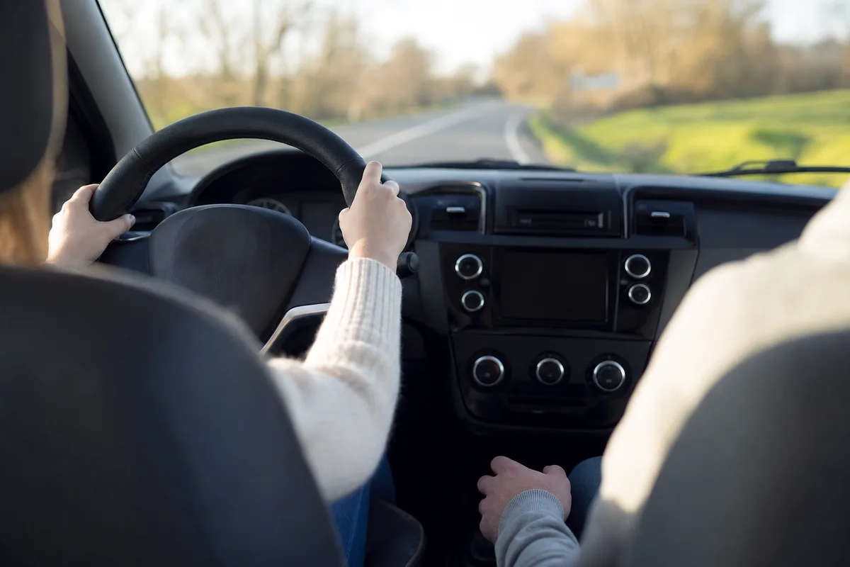 Leçon de conduite accompagnée avec les mains de l&rsquo;élève sur le volant