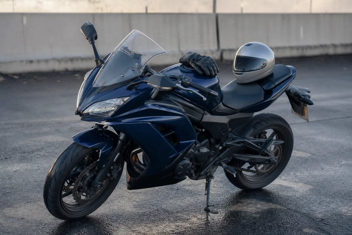 Casque de moto intégral posé sur une selle de motocyclette carénée unie, parking d&rsquo;auto-école au petit matin
