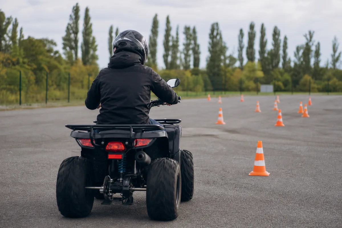 Élève au guidon d&rsquo;un quad sur une piste d&rsquo;exercice balisée de cônes